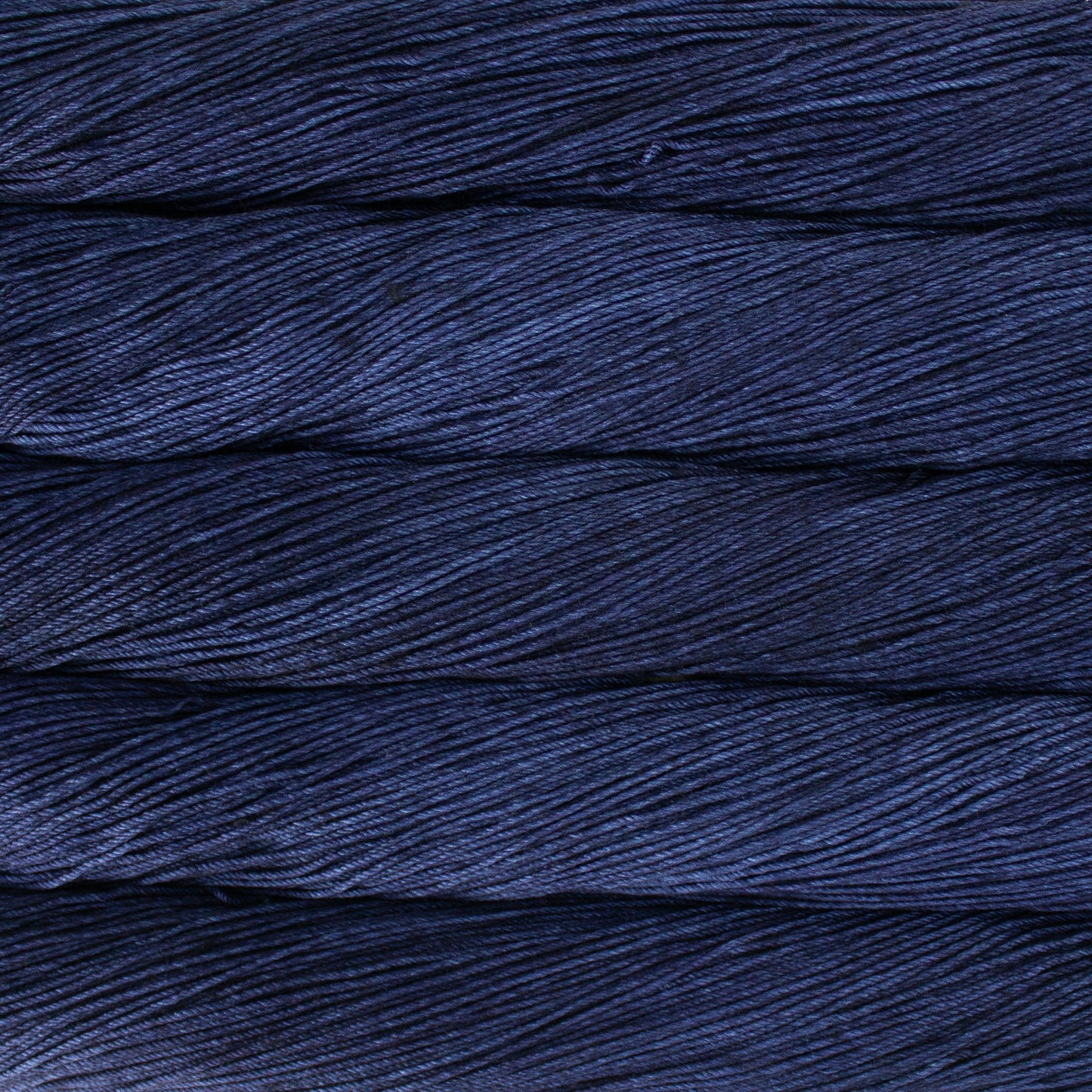 An image of skeins of Malabrigo Arroyo sport weight yarn in deep navy blue shades.