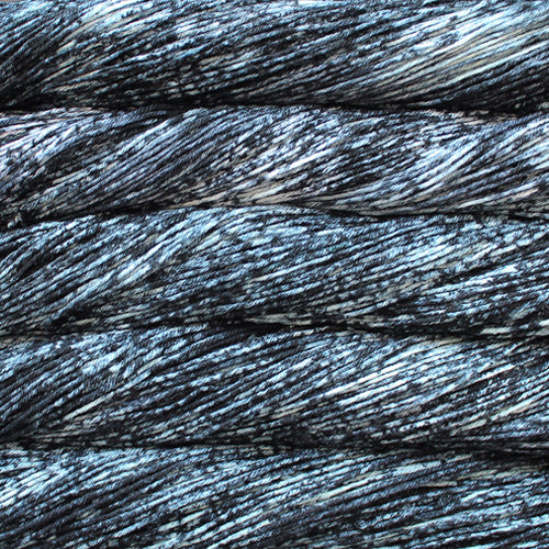 An image of skeins of Malabrigo Arroyo sport weight yarn in a white base with speckles of sky blue and charcoal.