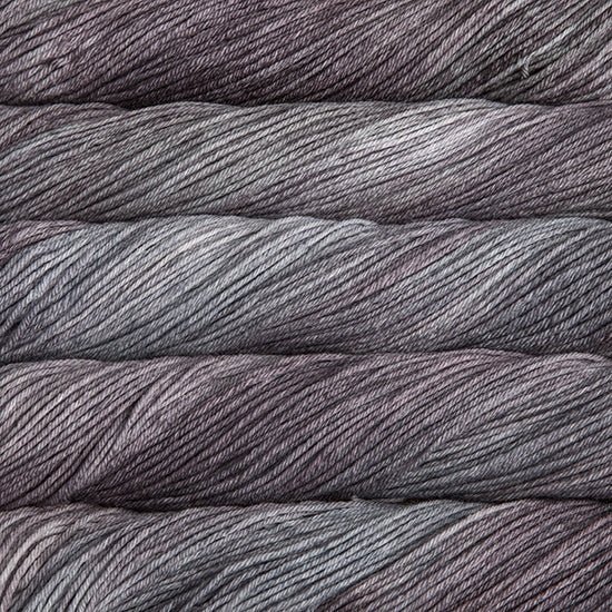 An image of skeins of Malabrigo Arroyo sport weight yarn in muted purple and charcoal shades.