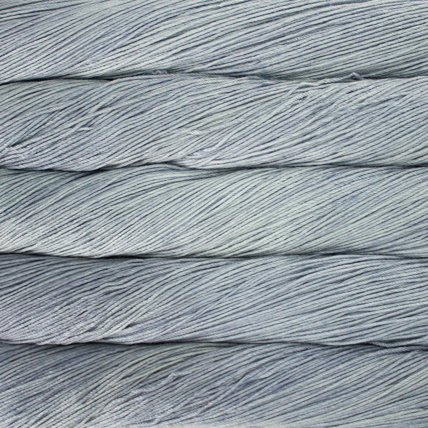 An image of skeins of Malabrigo Arroyo sport weight yarn in icy blue and gray shades.