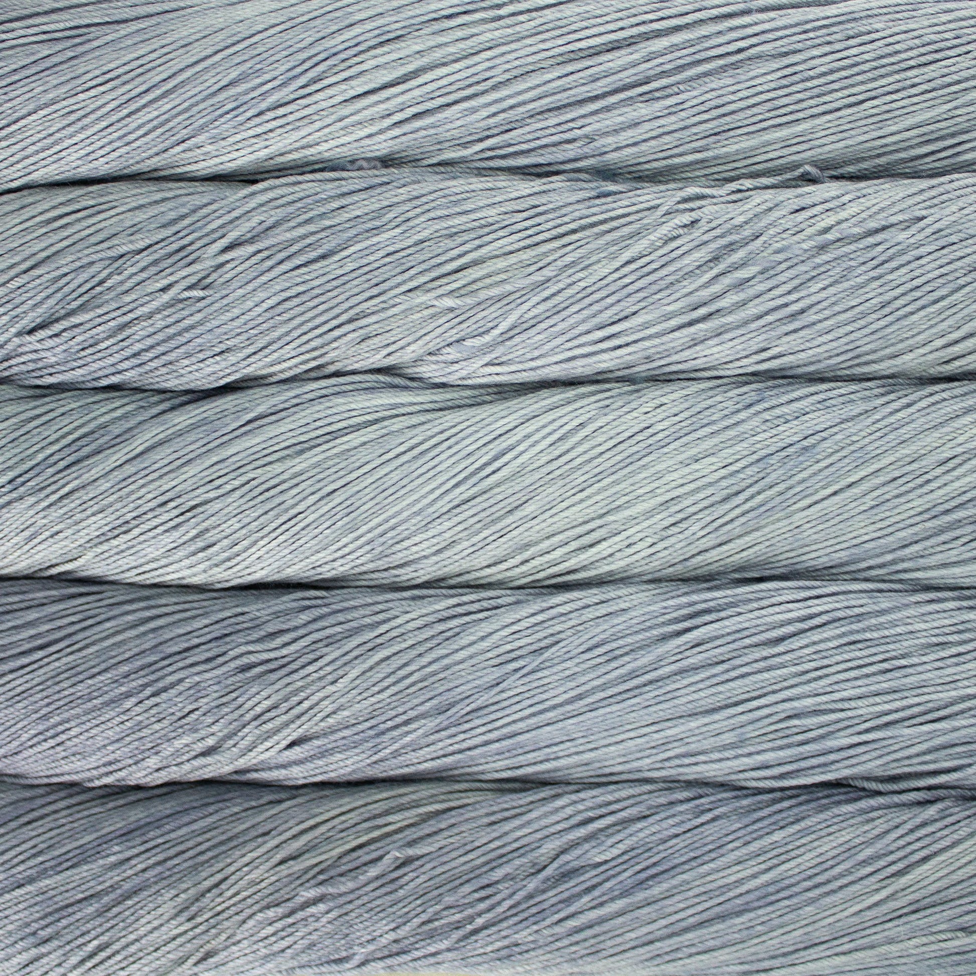An image of skeins of Malabrigo Arroyo sport weight yarn in icy blue and gray shades.