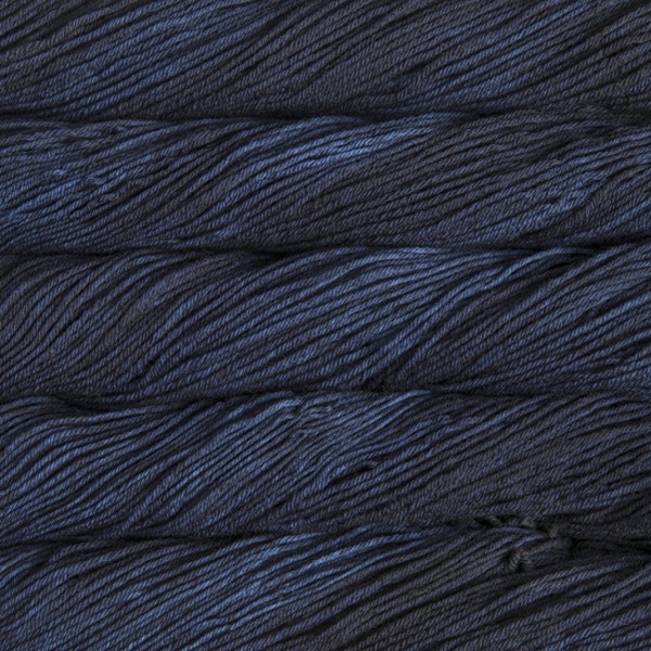An image of skeins of Malabrigo Arroyo sport weight yarn in deep blue shades.