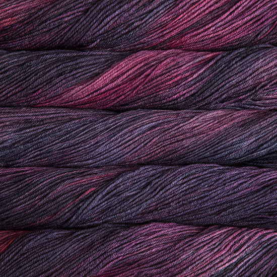 An image of skeins of Malabrigo Arroyo sport weight yarn in deep purple and magenta shades.