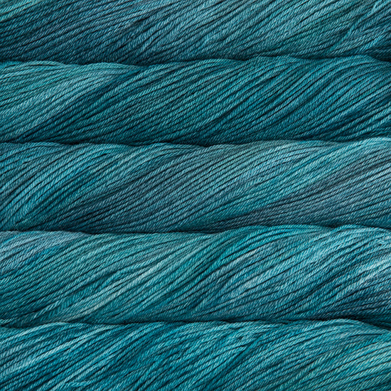 An image of skeins of Malabrigo Arroyo sport weight yarn in vibrant sea blue shades.