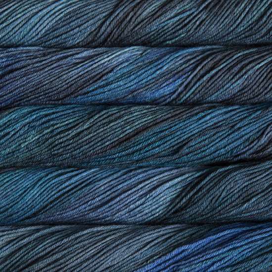 An image of skeins of Malabrigo Arroyo sport weight yarn in deep blue and charcoal shades.