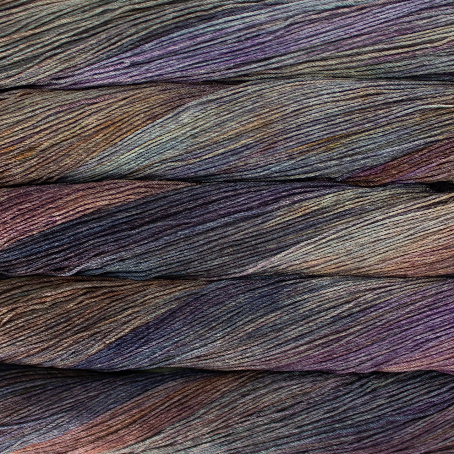 An image of skeins of Malabrigo Arroyo sport weight yarn in muted shades of brown, green, orange, and purple.