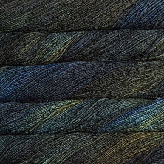 An image of skeins of Malabrigo Arroyo sport weight yarn in forest green and navy blue shades.