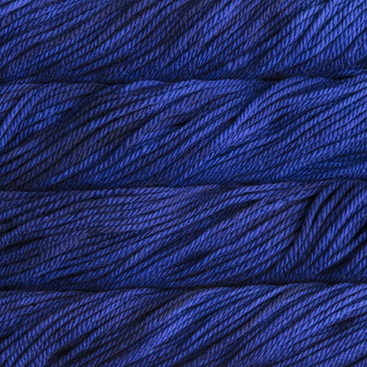 A close up image of skeins of Malabrigo Chunky bulky weight yarn in a deep indigo color.