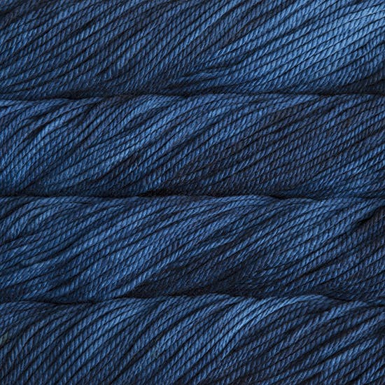 A close up image of skeins of Malabrigo Chunky bulky weight yarn in navy blue shades.