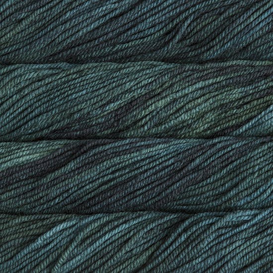A close up image of skeins of Malabrigo Chunky bulky weight yarn in dark green and charcoal shades.