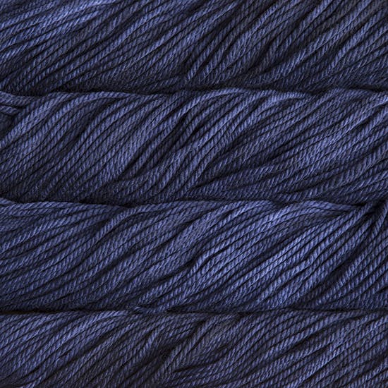 A close up image of skeins of Malabrigo Chunky bulky weight yarn in deep indigo shades.