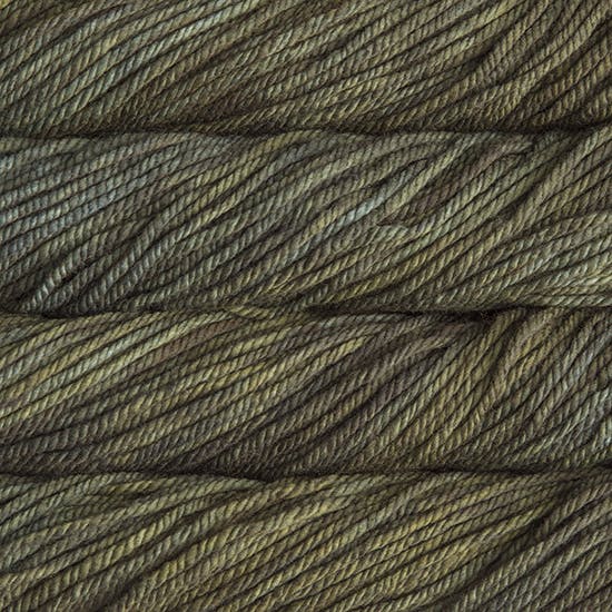 A close up image of skeins of Malabrigo Chunky bulky weight yarn in dark green and brown shades.