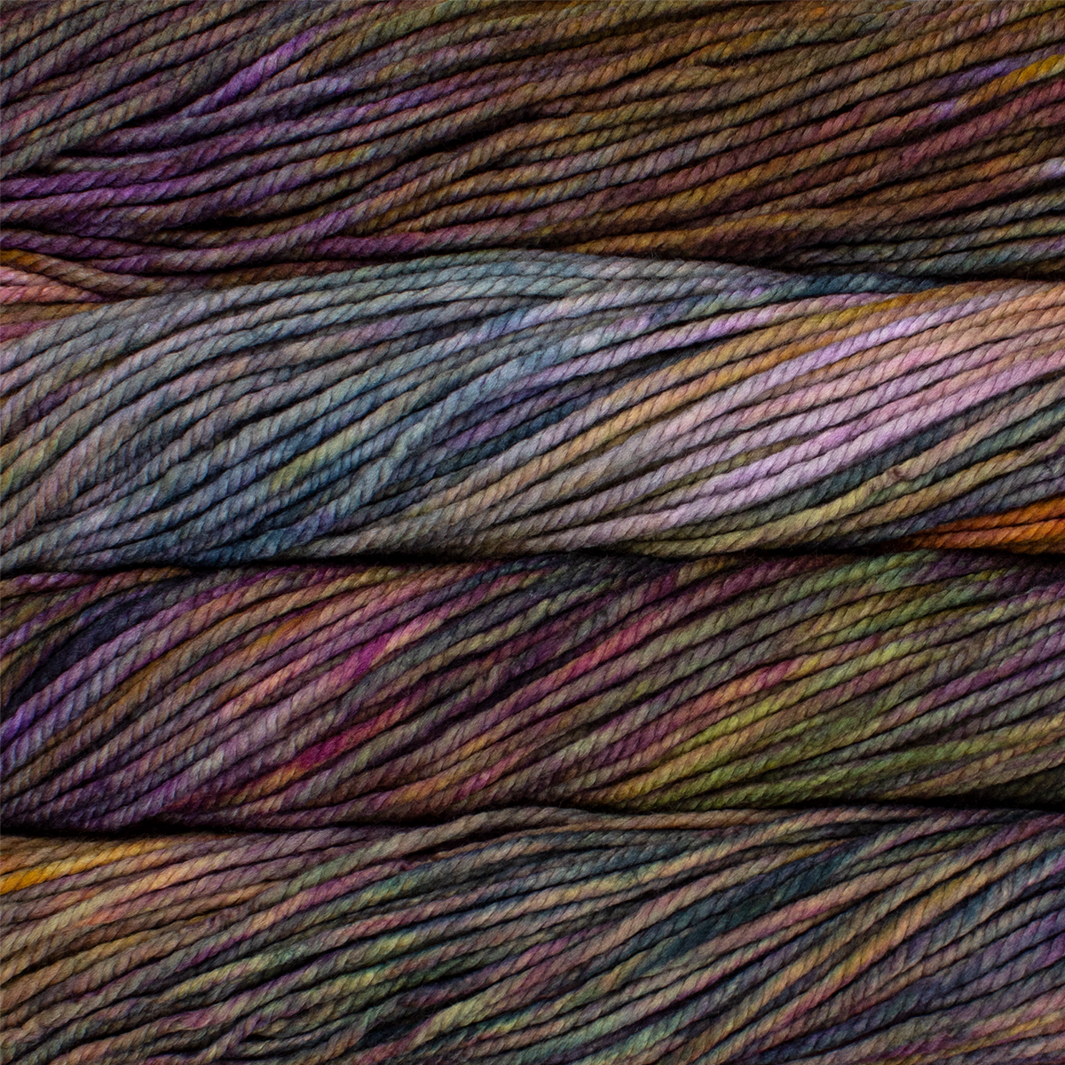 A close up image of skeins of Malabrigo Chunky bulky weight yarn in shades of brown, green, teal, and purple.