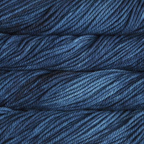 A close up image of skeins of Malabrigo Chunky bulky weight yarn in shades of deep blue.