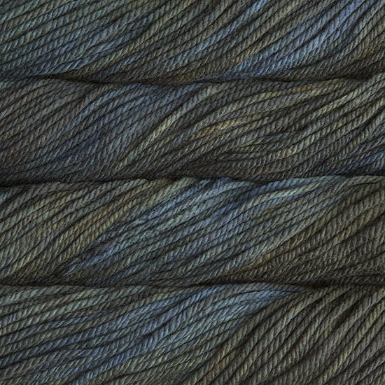 A close up image of skeins of Malabrigo Chunky bulky weight yarn in shades of forest green and teal.