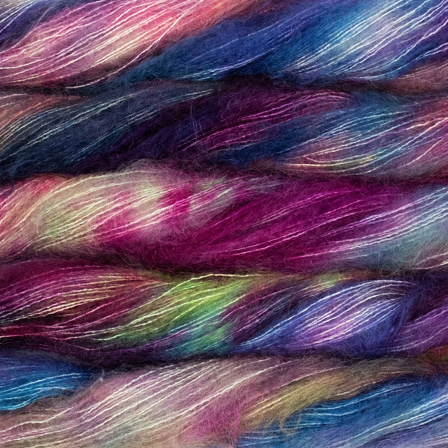 An image of multiple skeins of Malabrigo Mohair yarn in shades of blue, purple, pink, and green.