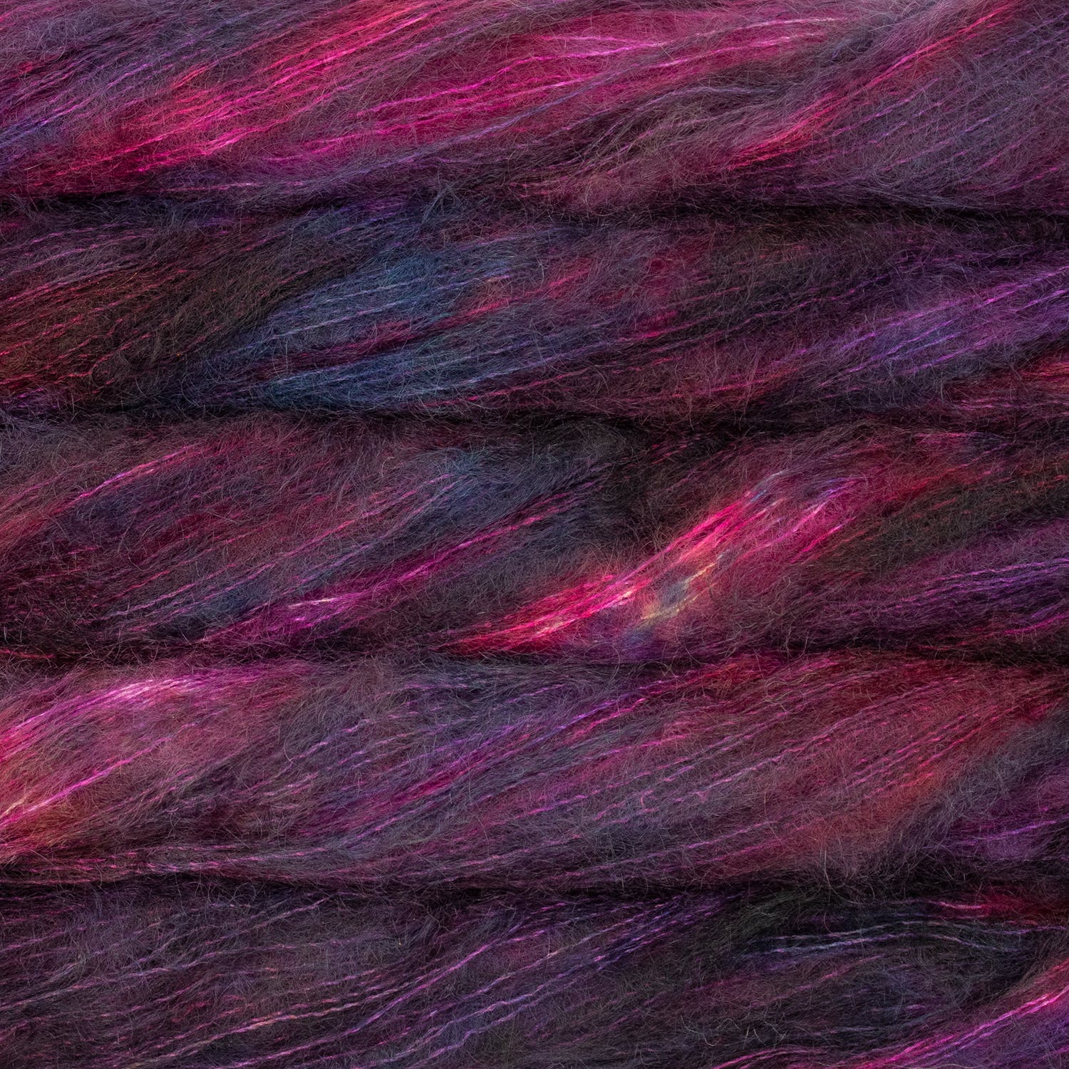 An image of multiple skeins of Malabrigo Mohair yarn in deep purple, red, and pink shades.