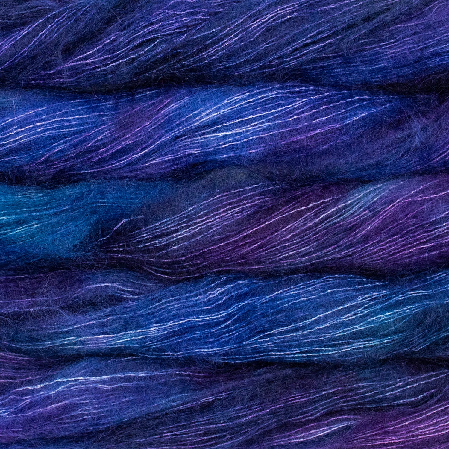 An image of multiple skeins of Malabrigo Mohair yarn in shades of electric blue and purple.