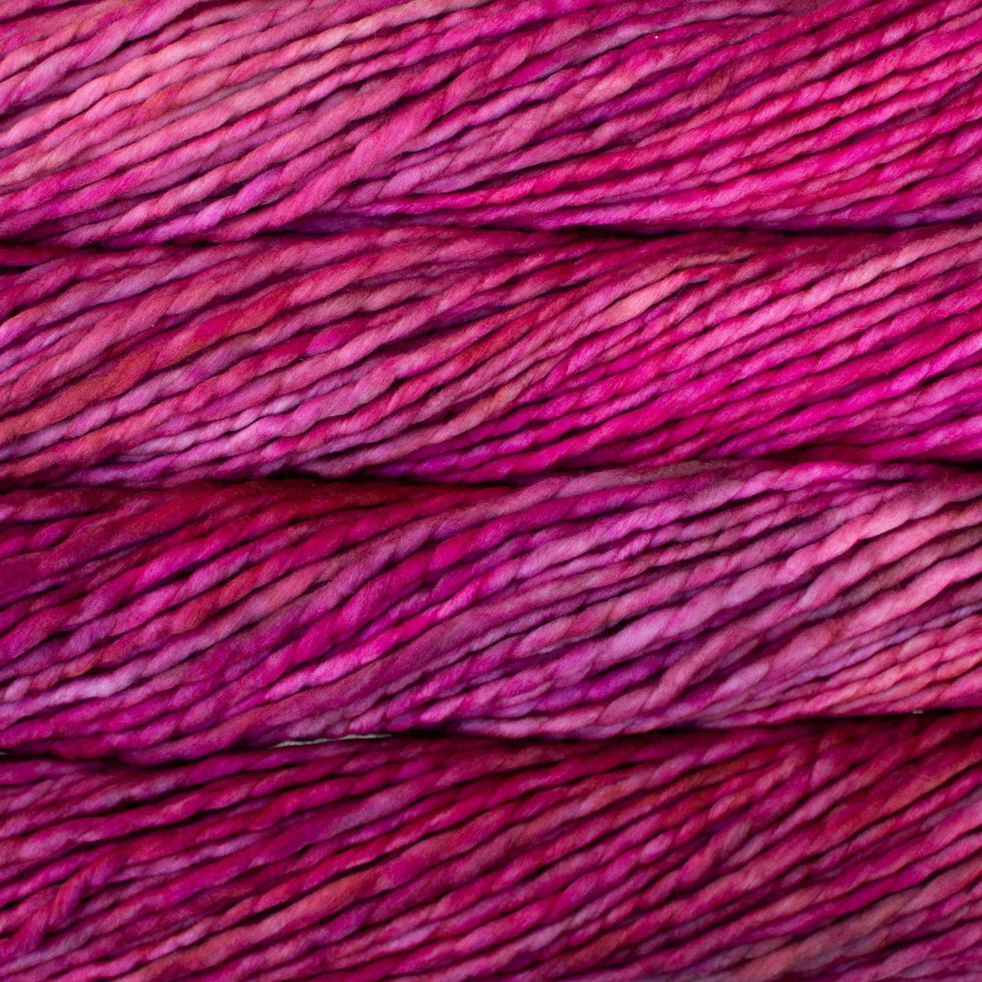 A close-up image of skeins of Malabrigo Rasta yarn in shades of pink, displaying the texture and color variation.
