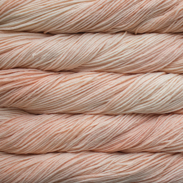 A close up of skeins of Malabrigo Rios worsted weight yarn in off white and pale pink colors