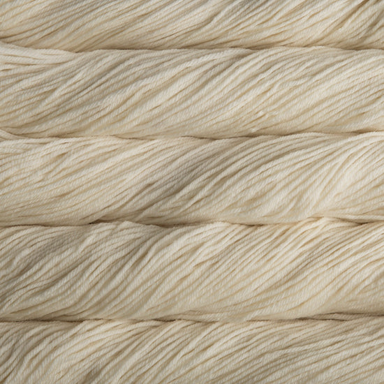 A close up of skeins of Malabrigo Rios worsted weight yarn in off white color