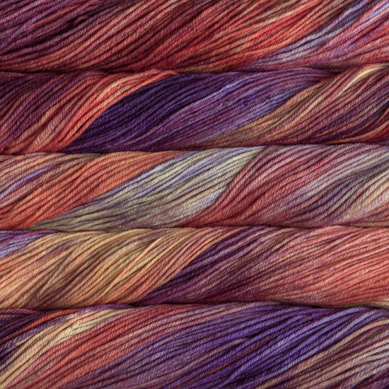 A close up of skeins of Malabrigo Rios worsted weight yarn in orange, yellow, purple, and beige colors