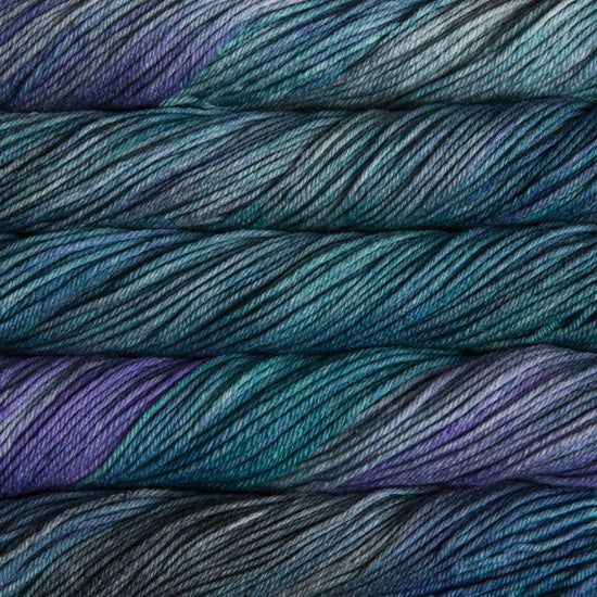 A close up of skeins of Malabrigo Rios worsted weight yarn in deep blue, teal, and green colors