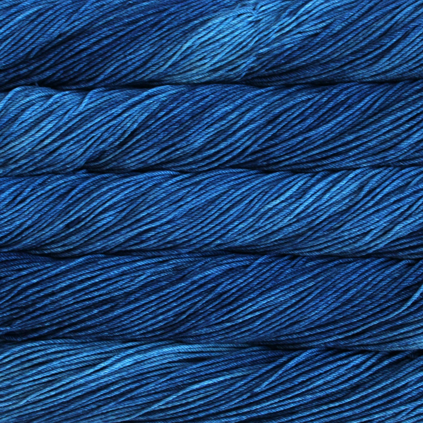 A close up of skeins of Malabrigo Rios worsted weight yarn in deep blue color