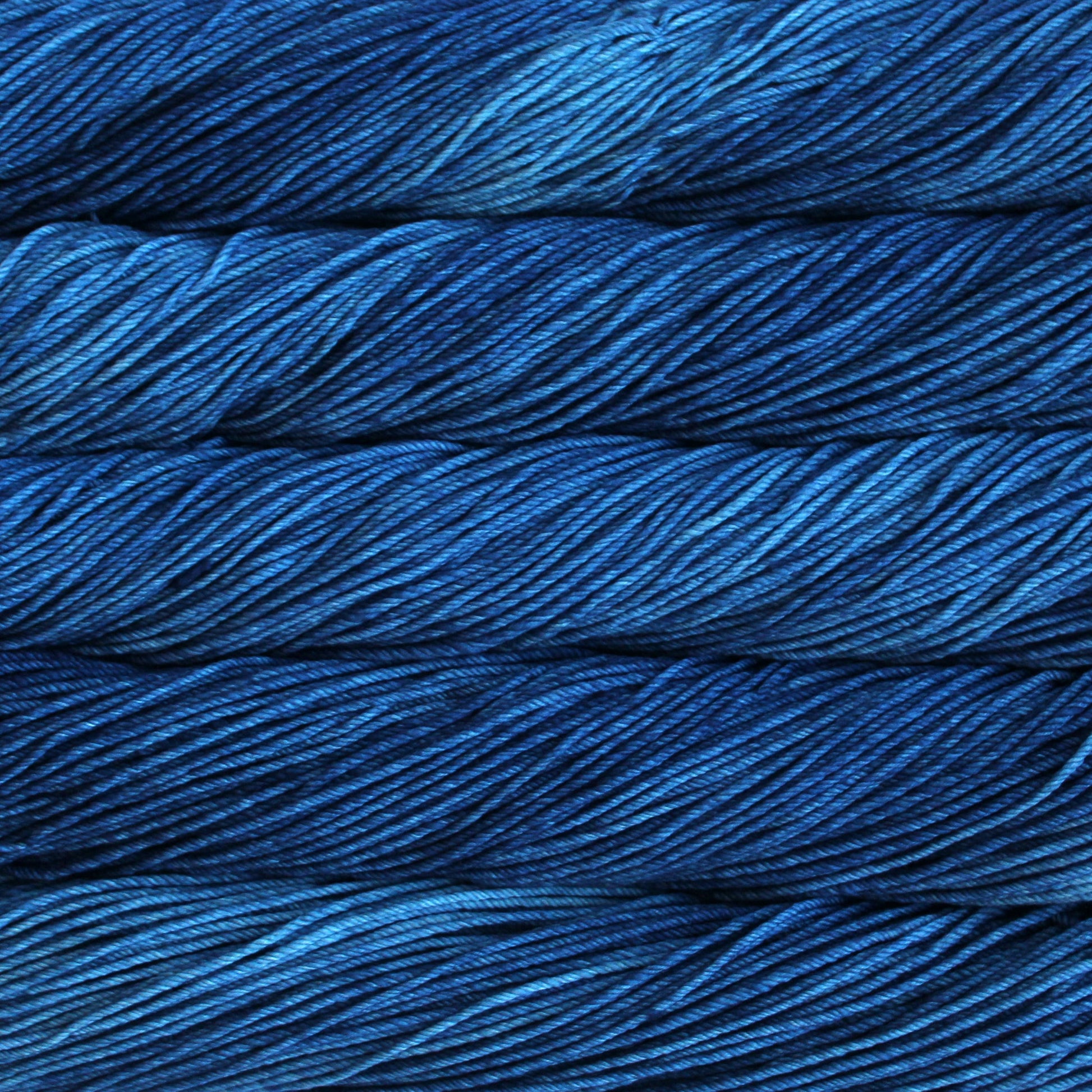A close up of skeins of Malabrigo Rios worsted weight yarn in deep blue color