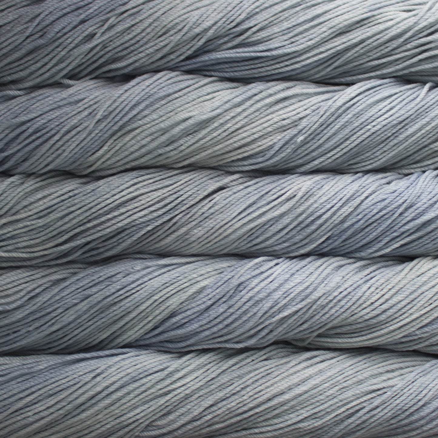 A close up of skeins of Malabrigo Rios worsted weight yarn in light grey color