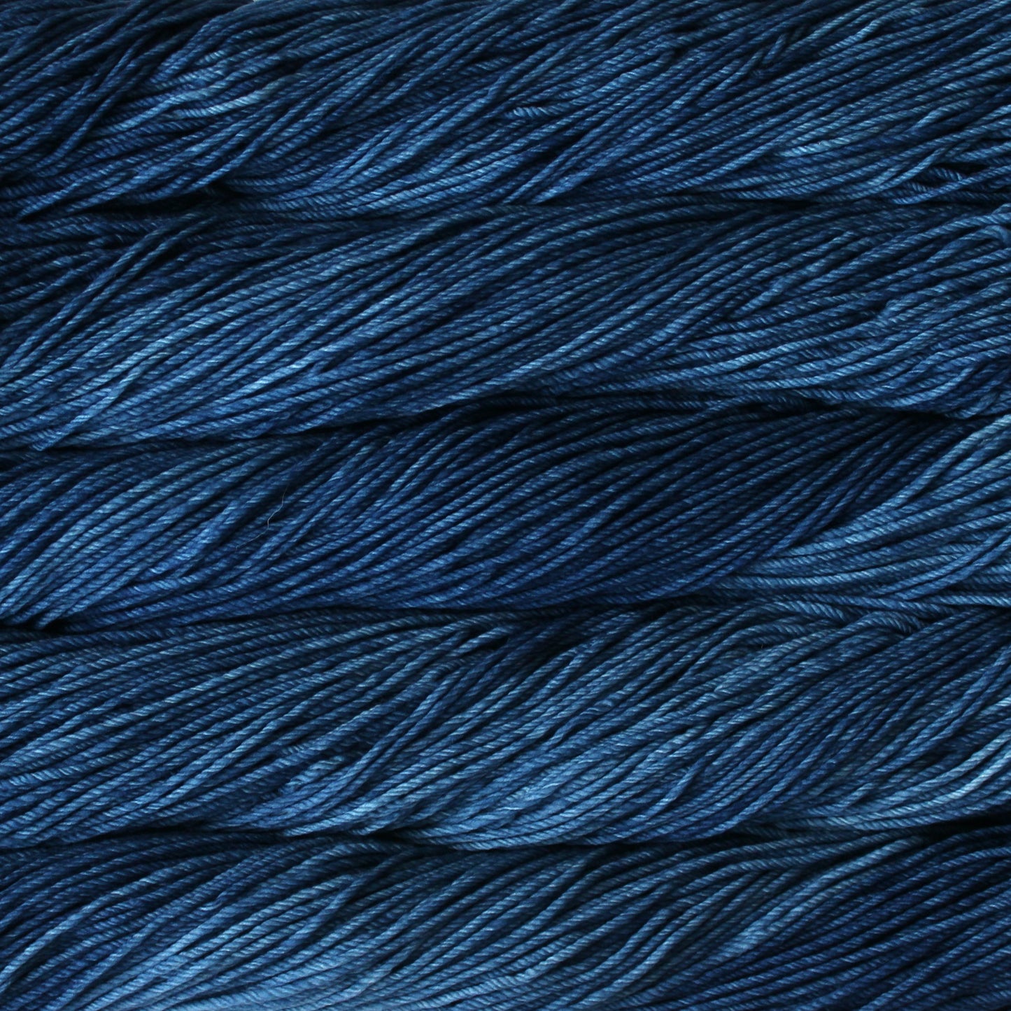 A close up of skeins of Malabrigo Rios worsted weight yarn in deep blue colors