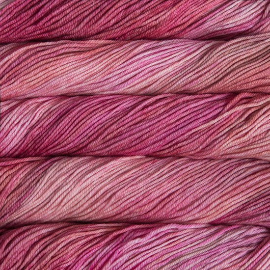 A close up of skeins of Malabrigo Rios worsted weight yarn in light and deep pink colors