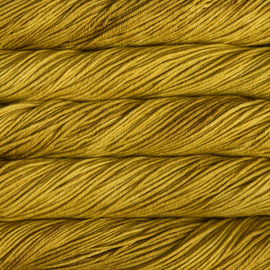 A close up of skeins of Malabrigo Rios worsted weight yarn in mustard yellow color
