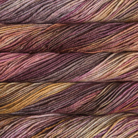 A close up of skeins of Malabrigo Rios worsted weight yarn in purple, brown, yellow, grey, and beige colors