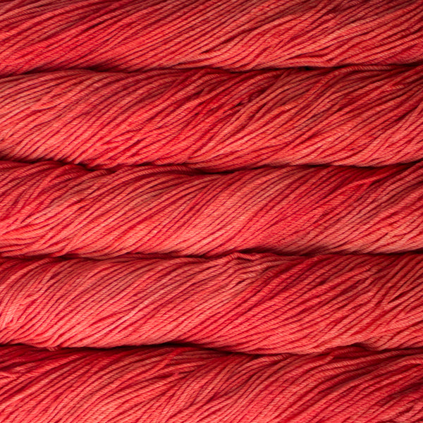 A close up of skeins of Malabrigo Rios worsted weight yarn in pink orange color