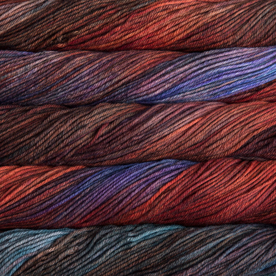 A close up of skeins of Malabrigo Rios worsted weight yarn in red orange, blue, teal, and brown colors