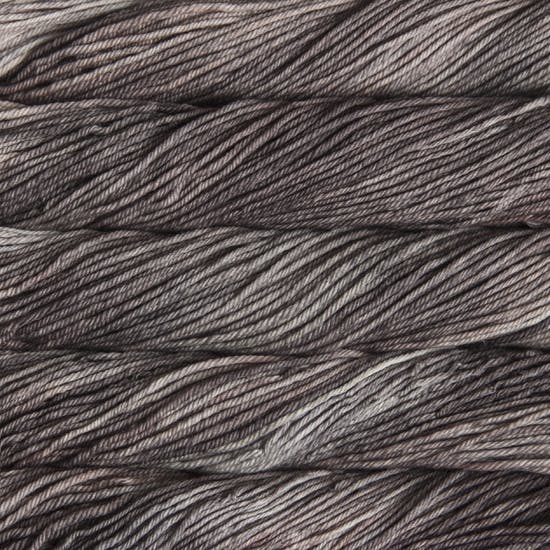 A close up of skeins of Malabrigo Rios worsted weight yarn in light and dark grey color