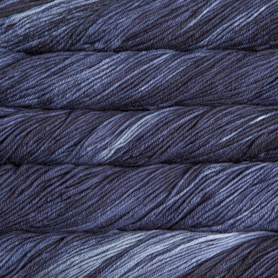 A close up of skeins of Malabrigo Rios worsted weight yarn in light and dark grey color