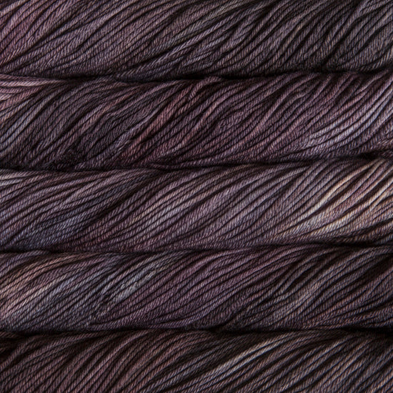 A close up of skeins of Malabrigo Rios worsted weight yarn in dark grey color