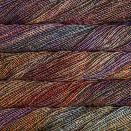 A close up of skeins of Malabrigo Rios worsted weight yarn in deep muted rainbow colors