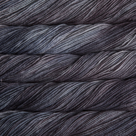 A close up of skeins of Malabrigo Rios worsted weight yarn in light and dark grey colors