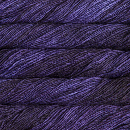 A close up of skeins of Malabrigo Rios worsted weight yarn in dark purple color