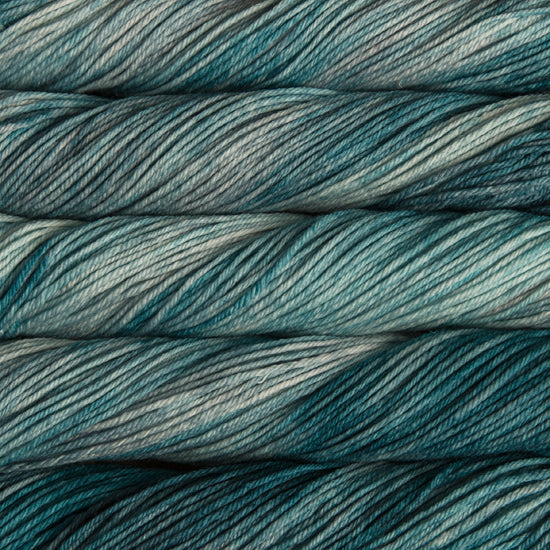 A close up of skeins of Malabrigo Rios worsted weight yarn in light and ark teal and grey colors