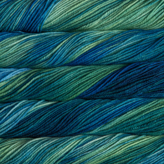 A close up of skeins of Malabrigo Rios worsted weight yarn in green, aqua, teal, and blue colors