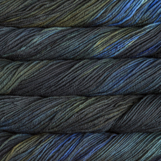 A close up of skeins of Malabrigo Rios worsted weight yarn in dark green and blue colors