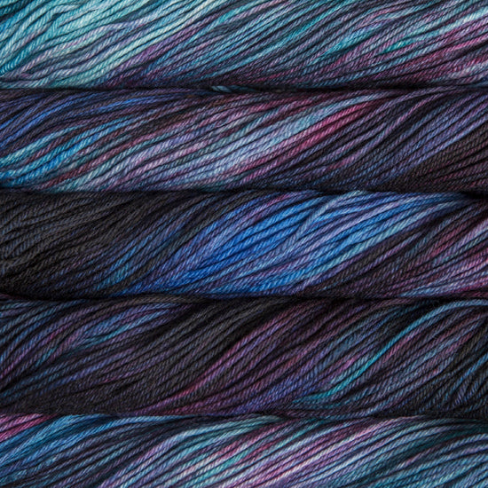 A close up of skeins of Malabrigo Rios worsted weight yarn in blue, aqua, mauve, and black colors