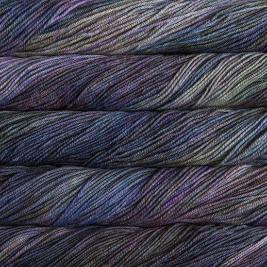 A close up of skeins of Malabrigo Rios worsted weight yarn in deep blue, green, and brown colors