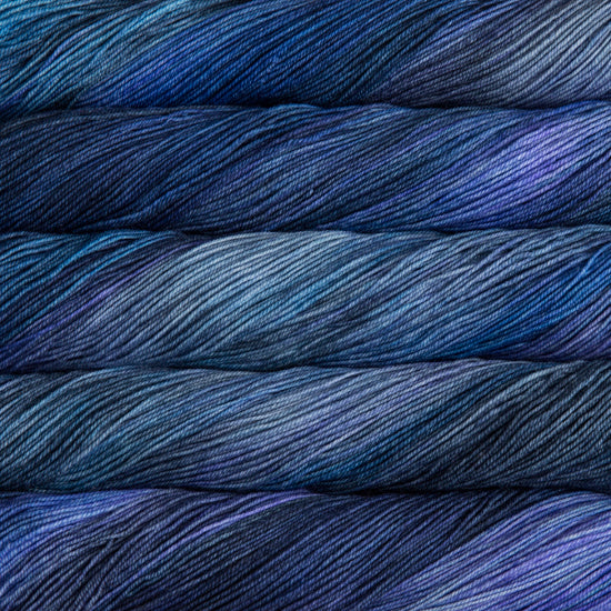A close-up image of skeins of Malabrigo Sock yarn in shades of deep blue and purple.