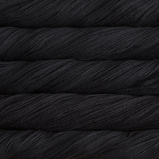 A close-up image of skeins of Malabrigo Sock yarn in a solid black color.