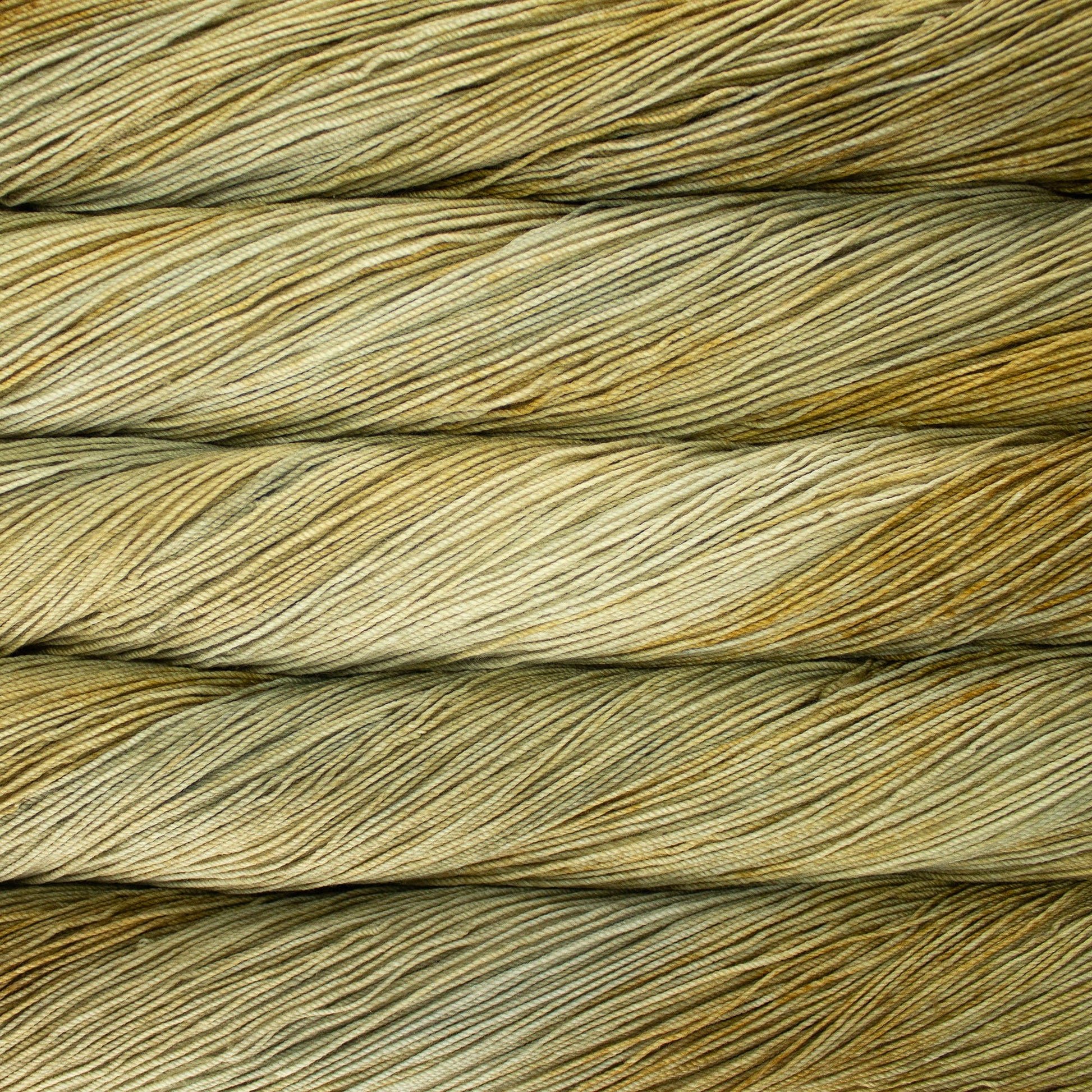 A close-up image of skeins of Malabrigo Sock yarn in light green and beige shades.